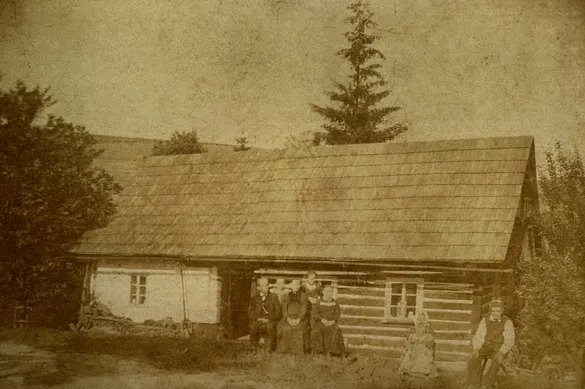Historická fotografie chalupy s rodinou z 19. století
