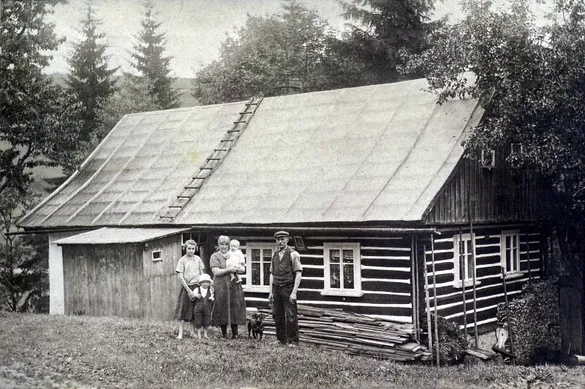 Rodina s dětmi před roubenou chalupou, archivní snímek